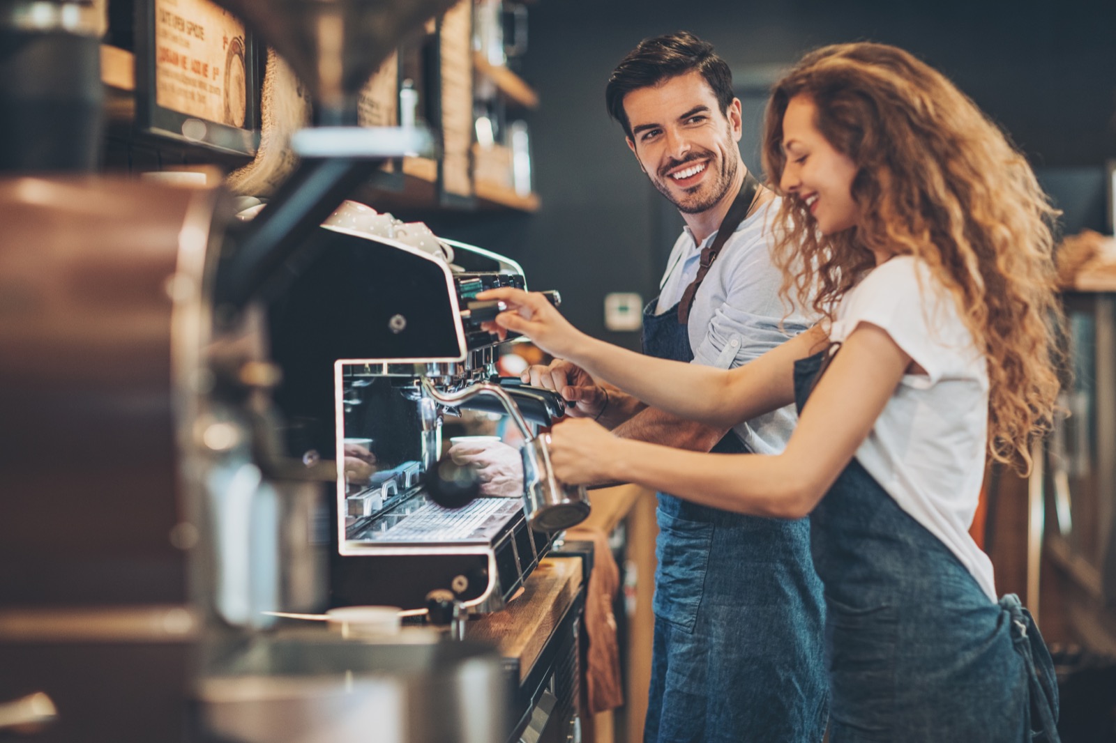 Two baristas working together at an espresso machine